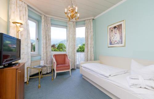 加尔米施-帕滕基兴维特尔斯巴赫尔瑞诗高级酒店的酒店客房设有一张床、一台电视和一扇窗户。