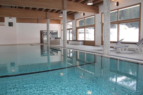 普拉洛尼昂拉瓦努瓦斯Epicéa Lodge Hôtel的大楼内的一个蓝色海水游泳池