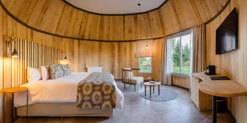维斯塔尔巴曼萨别墅酒店的卧室配有一张床铺,位于带木墙的房间内