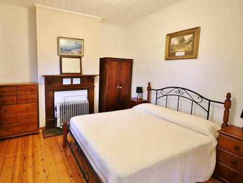 蒙塔Stonewall Cottage的一间卧室配有一张床、一个梳妆台和壁炉