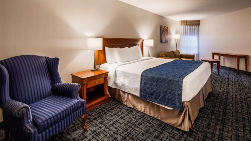布罗瑟德Best Western Hotel Brossard的配有一张床和一把椅子的酒店客房