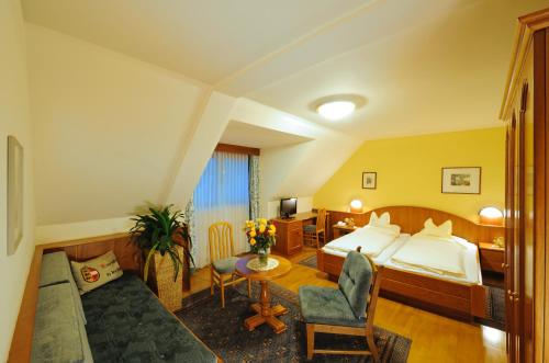 GuttaringGasthof Hotel Moser的酒店客房配有一张床铺和一张桌子。