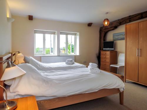 AldringhamMeadow View, Near Aldeburgh的一间卧室配有一张带白色床单的大床