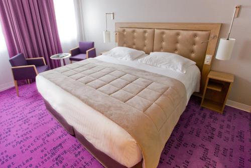雷恩安娜酒店的一间卧室配有一张大床和紫色地毯