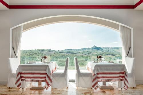 巴尼奥维尼奥尼阿尔伯格玛库奇旅馆的一间带两张桌子和大窗户的用餐室