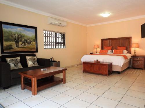 玛洛斯帕克Ubuntu Bed and Breakfast的一间卧室配有一张床、一张沙发和一张桌子