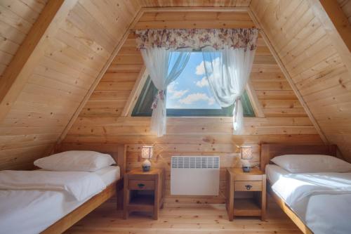 扎布利亚克Woodland的小木屋内的两张床,设有窗户