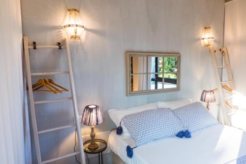 代森扎诺-德尔加达Villa Colli Storici的卧室配有白色的床和镜子