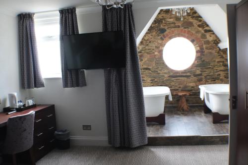 纽基维多利亚传奇酒店的浴室配有石墙、浴缸和水槽。