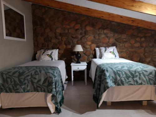 内尔斯普雷特Arend Cottage的石墙客房的两张床