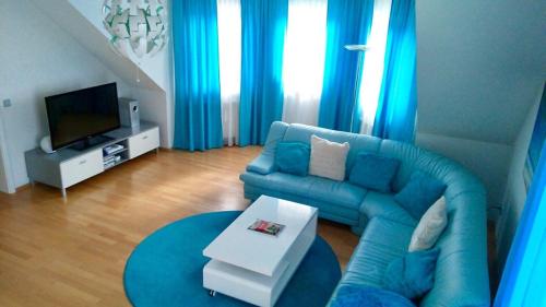 弗罗伊登施塔特Schwarzwald Appartment的客厅配有蓝色的沙发和电视