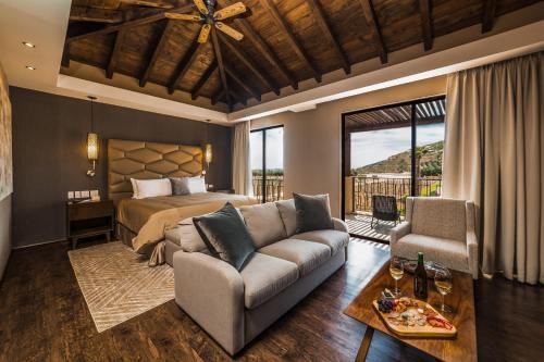 瓜达鲁佩镇El Cielo Resort的一间卧室配有一张床、一张沙发和一张桌子