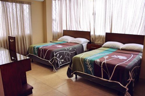 萨利纳斯Maluva的配有窗户和窗帘的客房内的两张床
