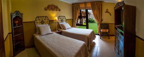 危地马拉Hostal Villa Toscana的酒店客房设有两张床和电视。