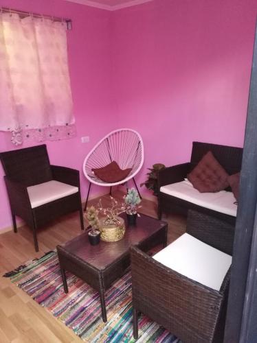 卡拉马Jallalla的客厅设有粉红色的墙壁、椅子和桌子