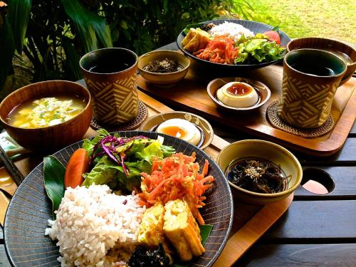 恩纳Akachichi Guesthouse的餐桌,上面有一盘饭和蔬菜