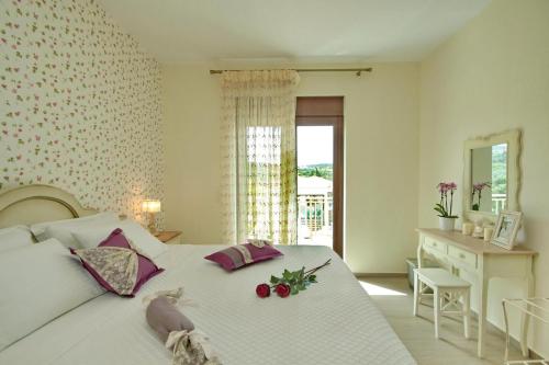 艾拉方索斯Elafonisos Resort的卧室配有带鲜花的白色床