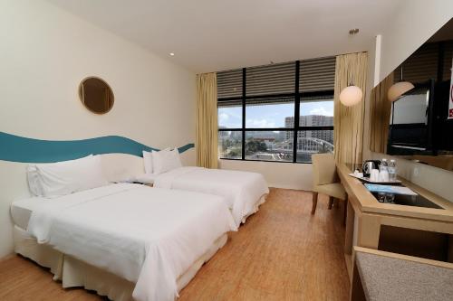 哥打京那巴鲁欧胜娜酒店 的酒店客房设有两张床和电视。