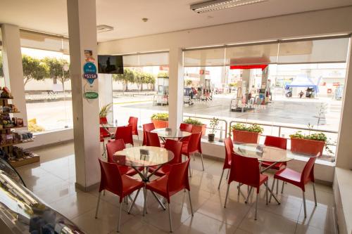帕卡斯马约El Puerto Hotel的餐厅设有红色的桌椅和窗户