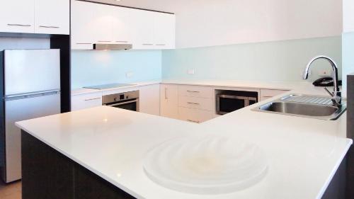 汤斯维尔Oaks Townsville Gateway Suites的厨房配有白色的柜台和水槽