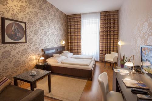 奥洛穆茨特里尼蒂酒店的一间卧室设有一张床和一间客厅。