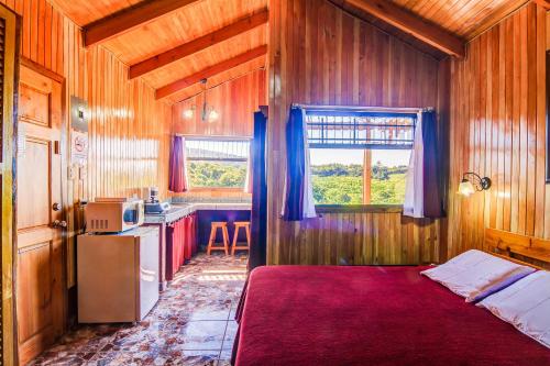 格雷西亚芒果谷酒店的一间卧室配有一张床,厨房配有窗户