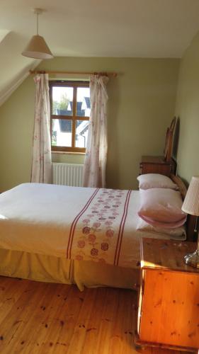莱特弗拉克Heatherhill Farm Cottage in Letterfrack beside Connemara National Park的一间卧室设有一张大床和窗户