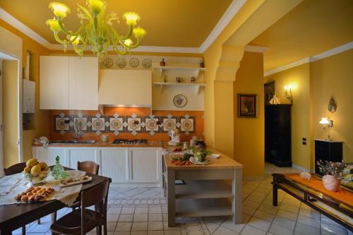 萨莱诺Donna Filomena Casa Vacanza di Charme的厨房设有黄色的墙壁和桌椅