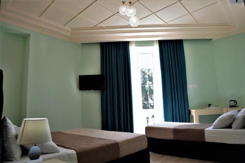都拉斯Hotel Veliera的一间卧室设有两张床和窗户。