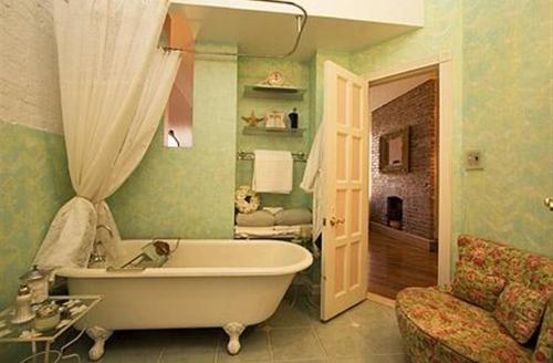纽约哈莱姆格兰住宿加早餐旅馆 的一间位于客房内的带白色浴缸的浴室