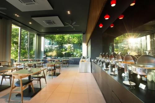 怡保The Haven All Suite Resort, Ipoh的餐厅设有桌椅和大窗户。