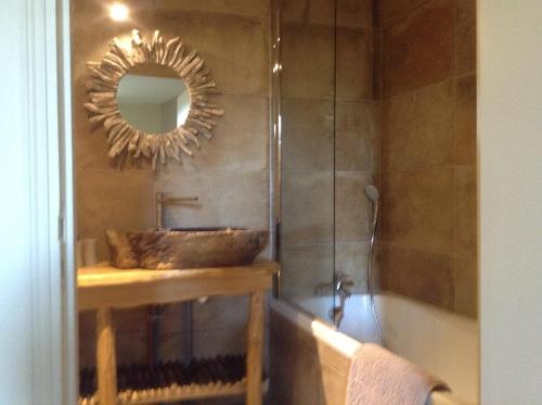 Saint-AuventAuberge de la vallee de la gorre的浴室配有盥洗盆、镜子和浴缸