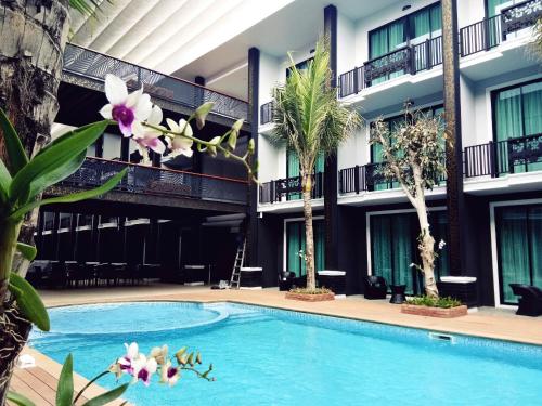 南府南府南通酒店的棕榈树酒店庭院内的游泳池