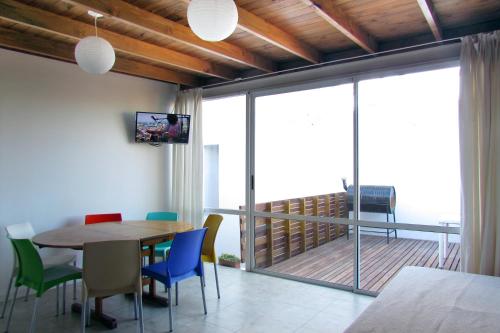 马德普拉塔PH Mogotes的一间带桌椅的用餐室和一个阳台