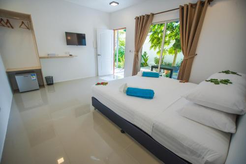 图杜Lagoon Villa Thoddoo的一间卧室配有一张带白色床单和蓝色枕头的大床。