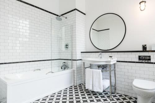 贝尔法斯特贝尔法斯特泰坦尼克酒店的白色的浴室设有浴缸、水槽和镜子