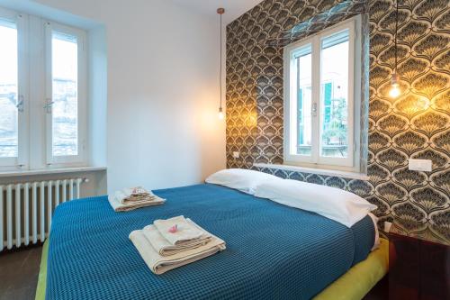 佩鲁贾Casa Malichi - Rètro Apartment - Centro Storico Perugia的一间卧室配有蓝色的床和毛巾