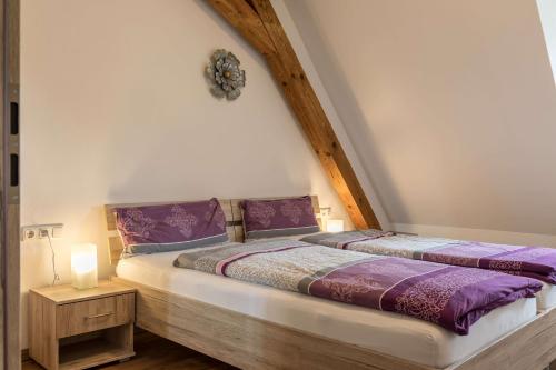 魏德豪斯Ferienwohnung Zetzl的一间卧室配有两张紫色床单