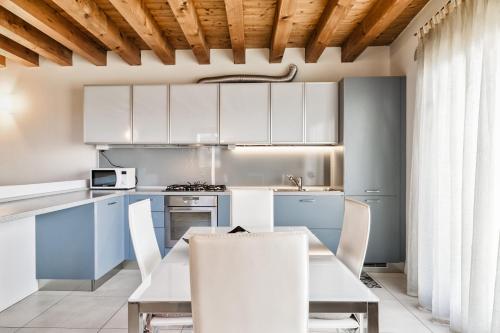 维琴察CASA GIORGIA - NEL CUORE DI VICENZA的厨房配有白色橱柜和桌椅