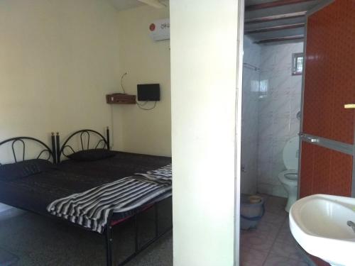 马尔冈Stay Goa的小房间设有一张床和一间浴室