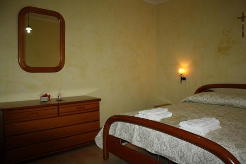 圣乔瓦尼·罗通多Mansarda Accogliente的一间卧室配有一张床、梳妆台和镜子