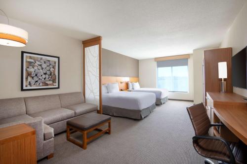 威斯敏斯特Hyatt Place Westminster Denver的酒店客房,配有床和沙发