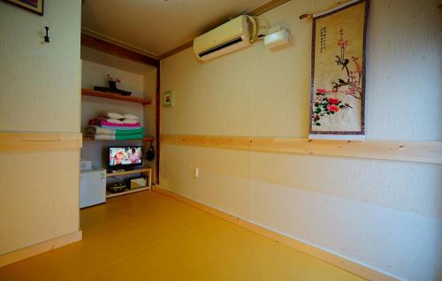 全州市江丹旅馆的客厅设有黄色地板和电视