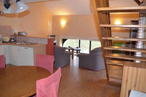 马尔梅迪Gîte O l'Hore的厨房以及带桌椅的用餐室。