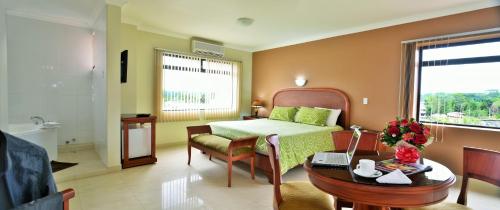 新洛哈Gran Hotel De Lago - Lago Agrio的一间卧室配有一张床、一张桌子和一张桌子