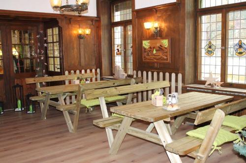 蒂蒂湖-新城Action Forest Hotel Titisee - nähe Badeparadies的餐厅设有木桌、长凳和窗户。