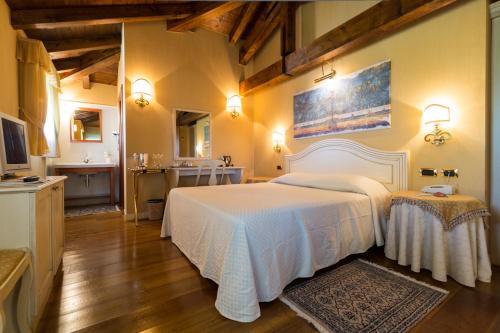 Mortegliano达南多酒店的一间带白色床的卧室和一间浴室