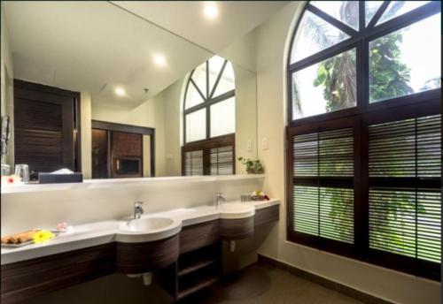 巴西古当Tanjung Puteri Golf and Resort Malaysia的大型浴室设有两个盥洗盆和大窗户。