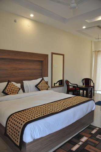 DoiwālaHotel KSS Inn的一间卧室配有一张大床和木制床头板