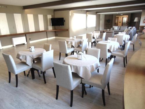 米兰米兰欢迎您酒店的一间设有白色桌椅的用餐室